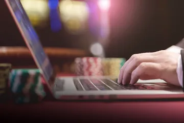 A professional dealer in a tuxedo greeting players at the roulette table, symbolizing the authentic live casino feel at 1XBED.